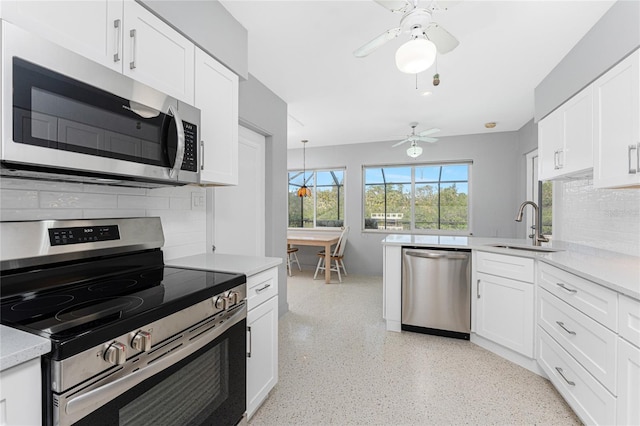 kitchen featuring a sink, stainless steel appliances, light countertops, and white cabinets