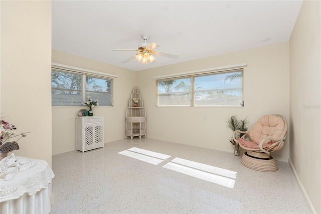 interior space with a ceiling fan and light speckled floor