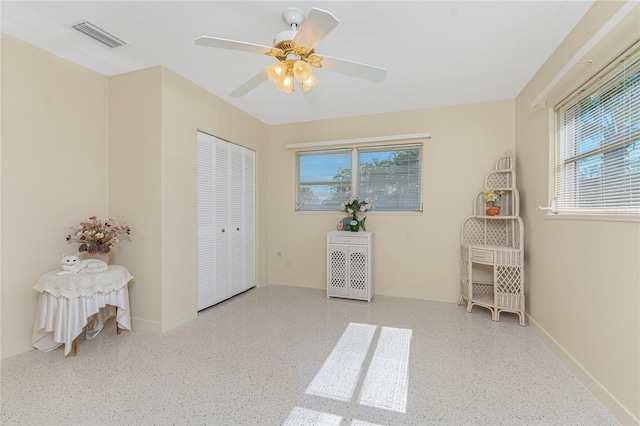 bedroom with light speckled floor, visible vents, and multiple windows