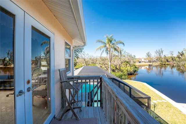 balcony featuring a water view and french doors