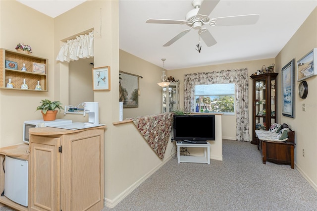 interior space with light colored carpet, ceiling fan, and baseboards