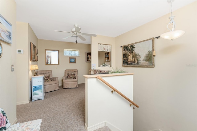 hallway with carpet, baseboards, and an upstairs landing