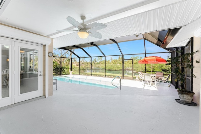 outdoor pool featuring glass enclosure, ceiling fan, a patio area, and french doors