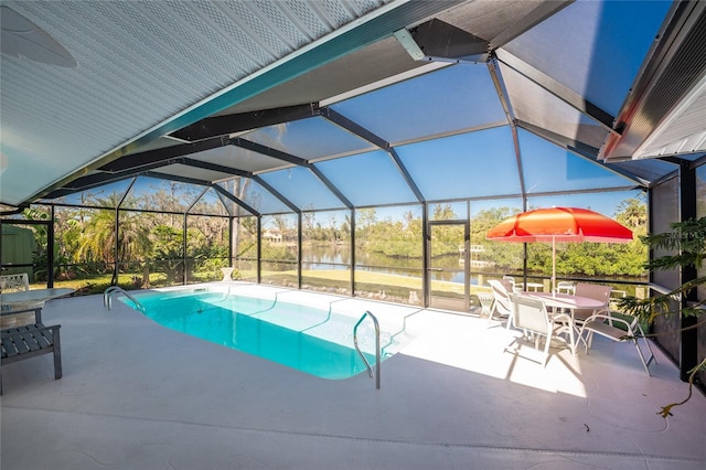 pool featuring a water view, glass enclosure, and a patio