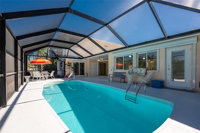 outdoor pool featuring a patio and glass enclosure