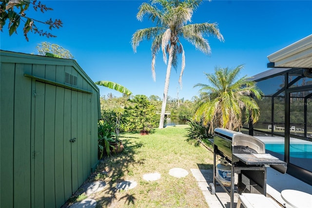 view of yard with a lanai, an outdoor pool, and a shed