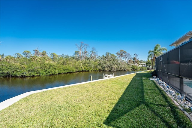 view of yard with a water view and a lanai