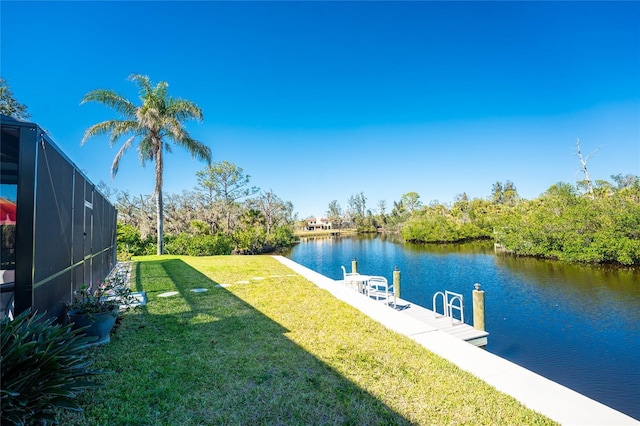 dock area with a water view, glass enclosure, and a lawn