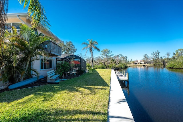 dock area featuring a lanai, a water view, and a yard