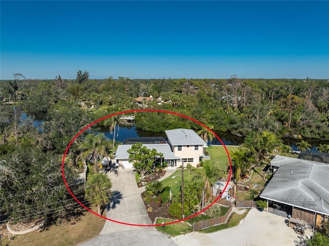 drone / aerial view featuring a water view and a wooded view