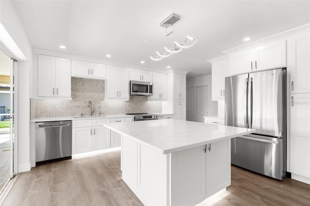 2160 Palm Tree Dr, Punta Gorda, FL 33950 - kitchen featuring appliances with stainless steel finishes, white cabinetry, tasteful backsplash, light countertops, and recessed lighting