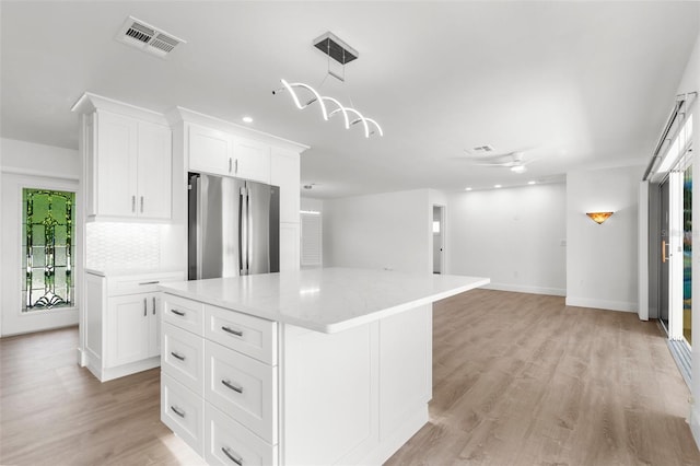 2160 Palm Tree Dr, Punta Gorda, FL 33950 - kitchen featuring freestanding refrigerator, light countertops, white cabinets, light wood-type flooring, and a center island