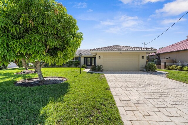 2160 Palm Tree Dr, Punta Gorda, FL 33950 - ranch-style house featuring a garage, stucco siding, decorative driveway, a tiled roof, and french doors