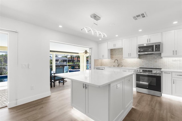 2160 Palm Tree Dr, Punta Gorda, FL 33950 - kitchen featuring stainless steel appliances, plenty of natural light, tasteful backsplash, light wood-type flooring, and recessed lighting