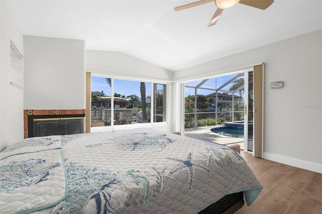 2160 Palm Tree Dr, Punta Gorda, FL 33950 - bedroom with lofted ceiling, wood finished floors, access to exterior, ceiling fan, and a tiled fireplace