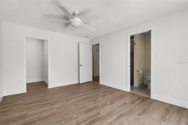 2160 Palm Tree Dr, Punta Gorda, FL 33950 - unfurnished bedroom with ensuite bathroom, light wood-type flooring, ceiling fan, a walk in closet, and a closet
