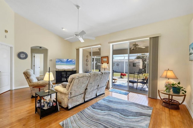 living room with ceiling fan, vaulted ceiling, and light hardwood / wood-style floors