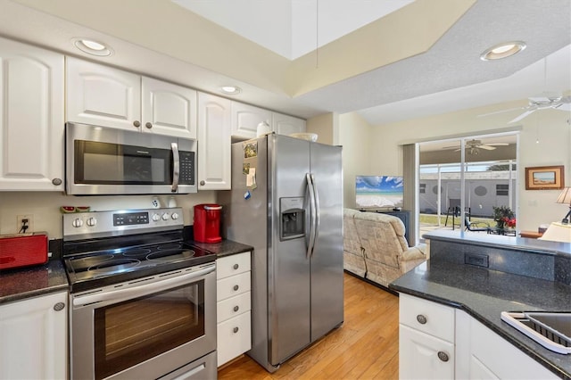 kitchen with appliances with stainless steel finishes, ceiling fan, light wood-type flooring, and white cabinetry