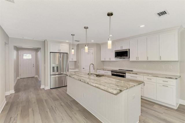 kitchen featuring a kitchen island with sink, appliances with stainless steel finishes, white cabinets, and a sink