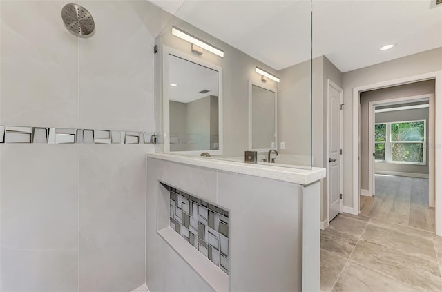 bathroom featuring recessed lighting, vanity, baseboards, and walk in shower