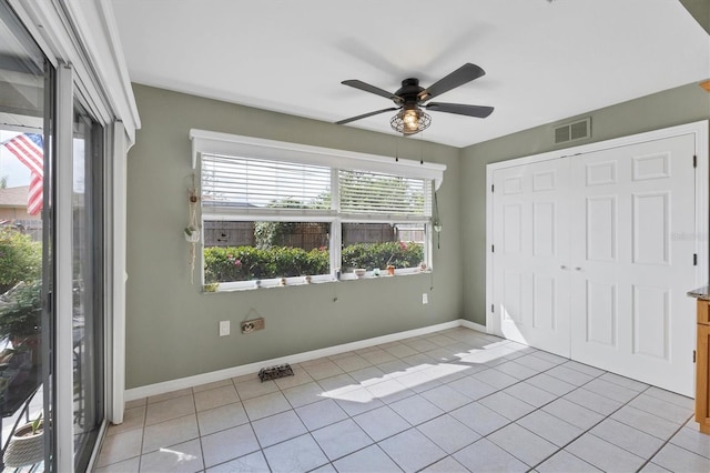 unfurnished bedroom with light tile patterned floors, multiple windows, a closet, and visible vents