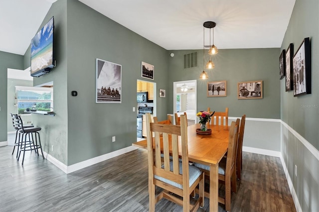 dining space with high vaulted ceiling, dark wood finished floors, visible vents, and baseboards