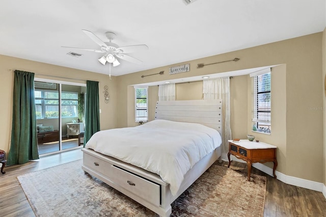 bedroom featuring wood finished floors, a ceiling fan, baseboards, visible vents, and access to exterior