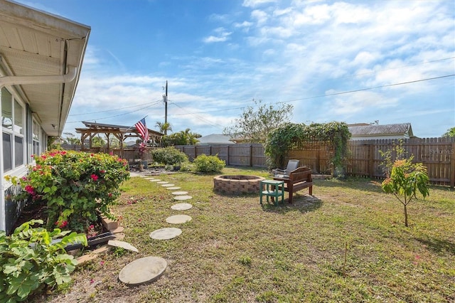 view of yard with a fenced backyard and a fire pit