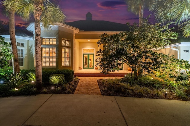 exterior entry at dusk featuring french doors