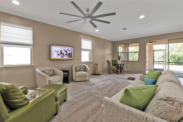 living room with crown molding, plenty of natural light, and carpet floors