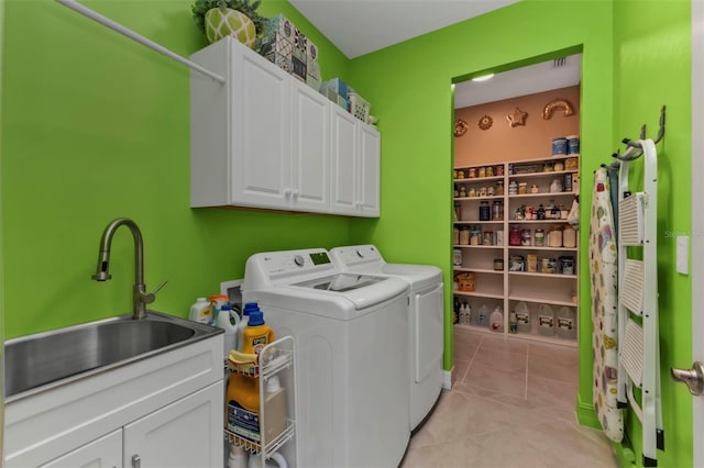 laundry room featuring cabinets, washing machine and dryer, sink, and light tile patterned flooring