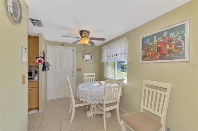 dining space featuring light tile patterned flooring and ceiling fan