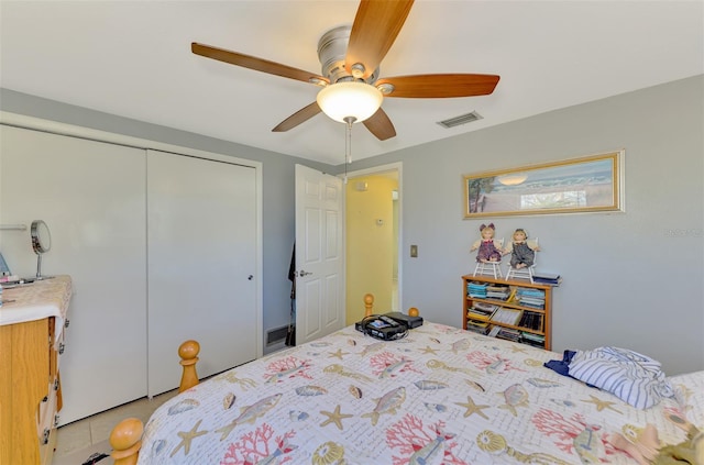 bedroom with light tile patterned flooring, a closet, and ceiling fan