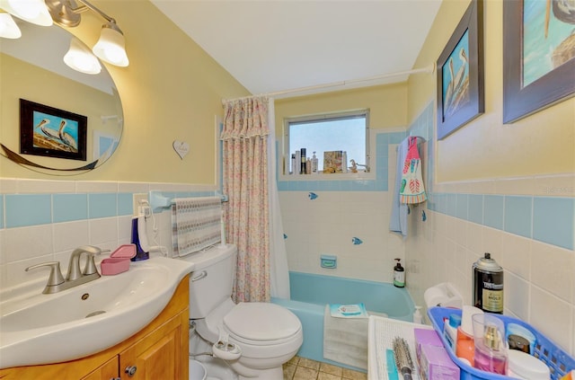 full bathroom with tile walls, toilet, vanity, and shower / tub combo with curtain