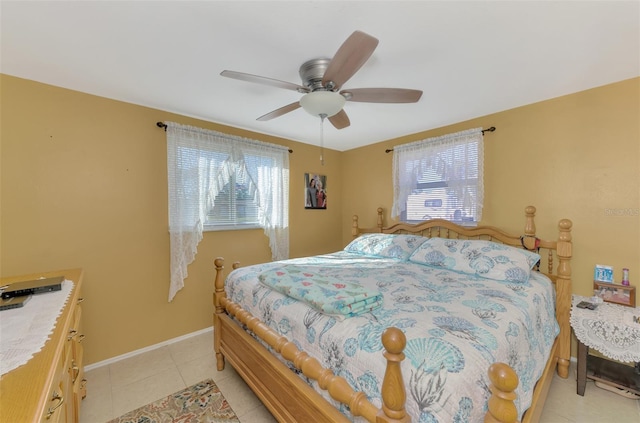 tiled bedroom featuring ceiling fan and multiple windows