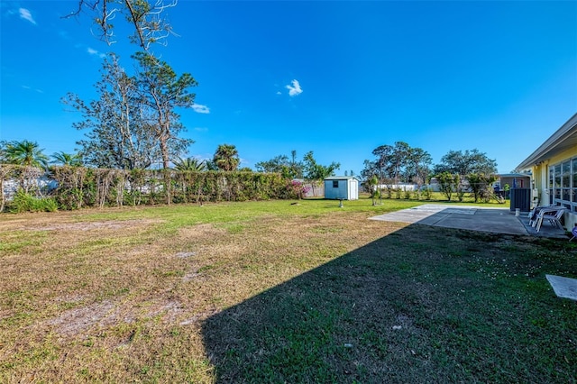 view of yard featuring a storage unit and a patio