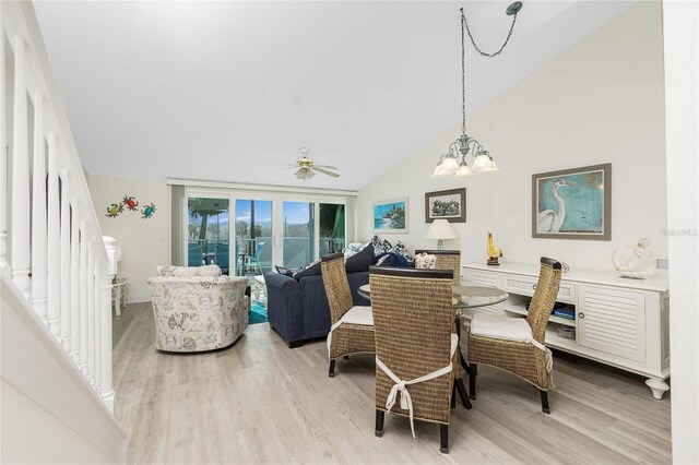 2255 N Beach Rd Unit 13, Englewood, FL 34223 - dining area featuring light wood-style floors, vaulted ceiling, and ceiling fan with notable chandelier