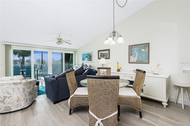2255 N Beach Rd Unit 13, Englewood, FL 34223 - dining room featuring light wood finished floors, vaulted ceiling, and ceiling fan with notable chandelier