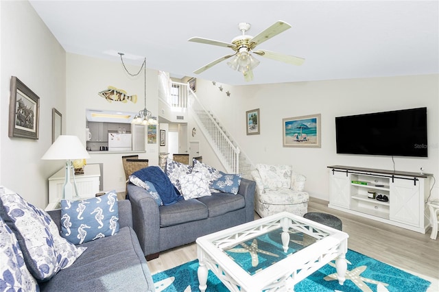 2255 N Beach Rd Unit 13, Englewood, FL 34223 - living area featuring vaulted ceiling, ceiling fan with notable chandelier, stairway, and light wood finished floors