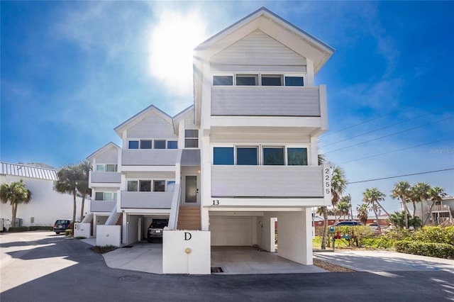 beach home with a garage, driveway, and a carport