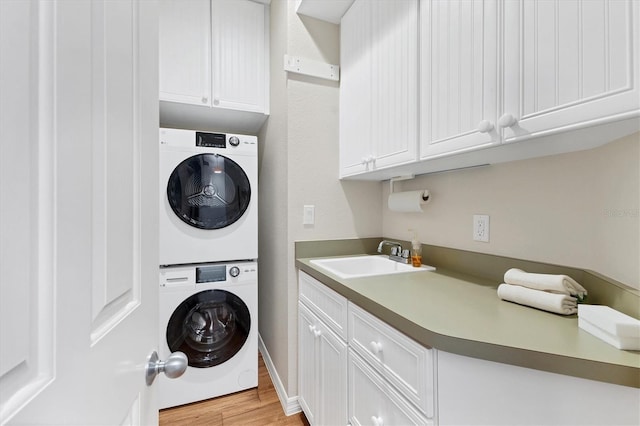 7430 Palm Island Dr Unit 3813, Placida, FL 33946 - washroom featuring cabinets, stacked washer / dryer, sink, and light hardwood / wood-style floors