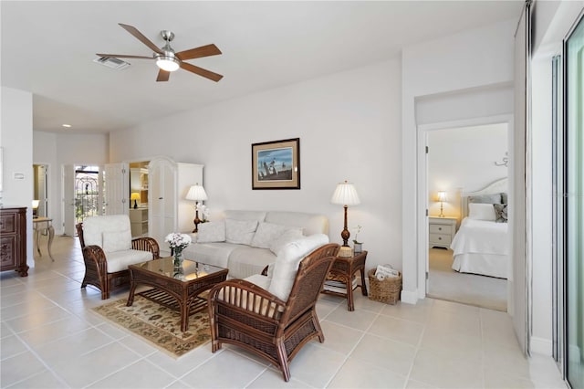 living area with light tile patterned flooring, a ceiling fan, and visible vents