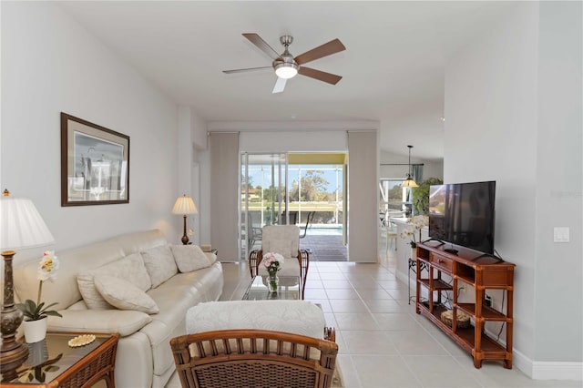 living room with light tile patterned floors, a ceiling fan, and baseboards