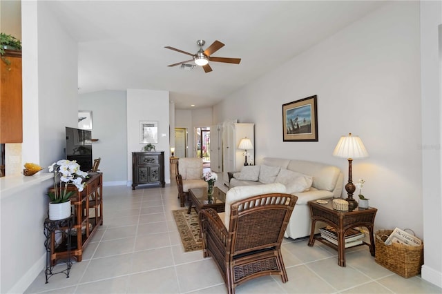 living area with light tile patterned flooring, baseboards, a ceiling fan, and vaulted ceiling