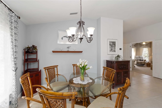 dining space featuring tile patterned flooring, visible vents, an inviting chandelier, and vaulted ceiling