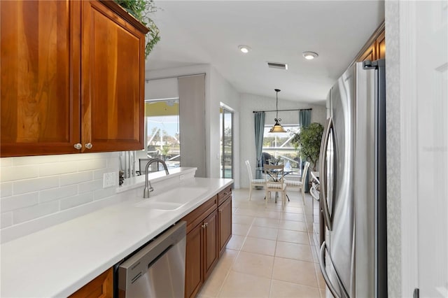 kitchen with light tile patterned floors, visible vents, a sink, stainless steel appliances, and light countertops