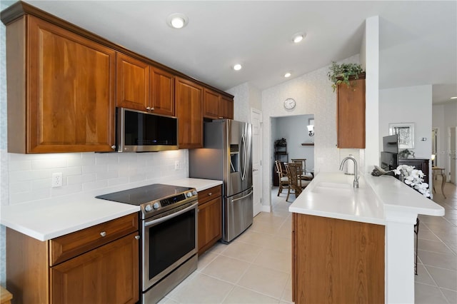 kitchen featuring tasteful backsplash, stainless steel appliances, a peninsula, light tile patterned floors, and lofted ceiling