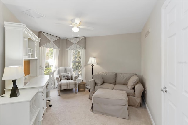 sitting room featuring light carpet, baseboards, and ceiling fan