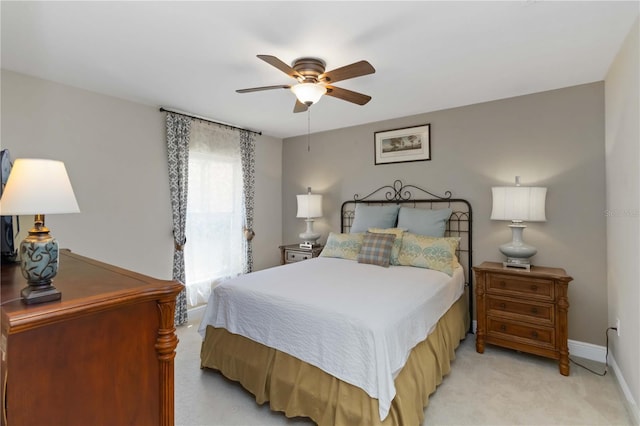 bedroom featuring light colored carpet, a ceiling fan, and baseboards