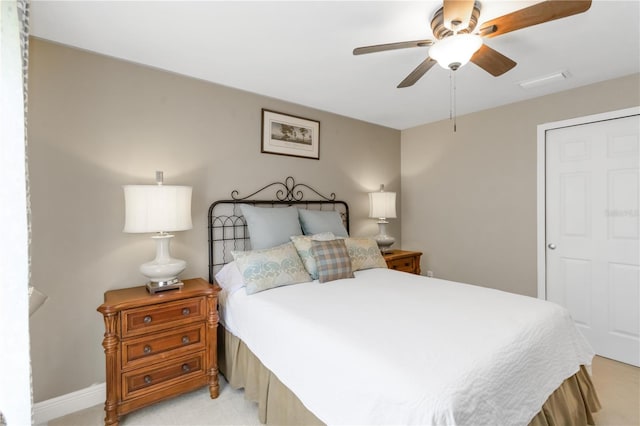 bedroom featuring light carpet and a ceiling fan